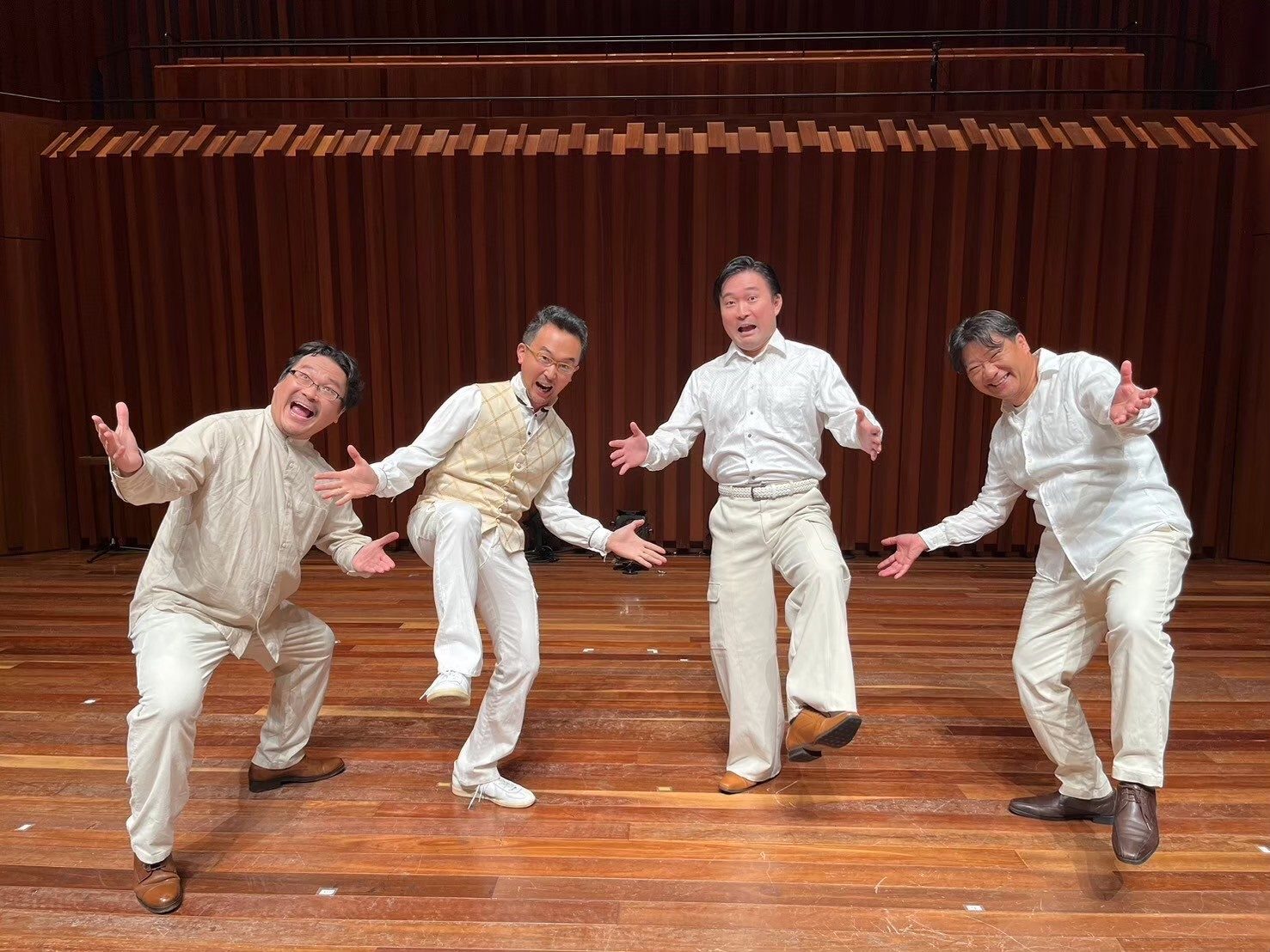 白い衣装でおどけたポーズをとる男声メンバー
