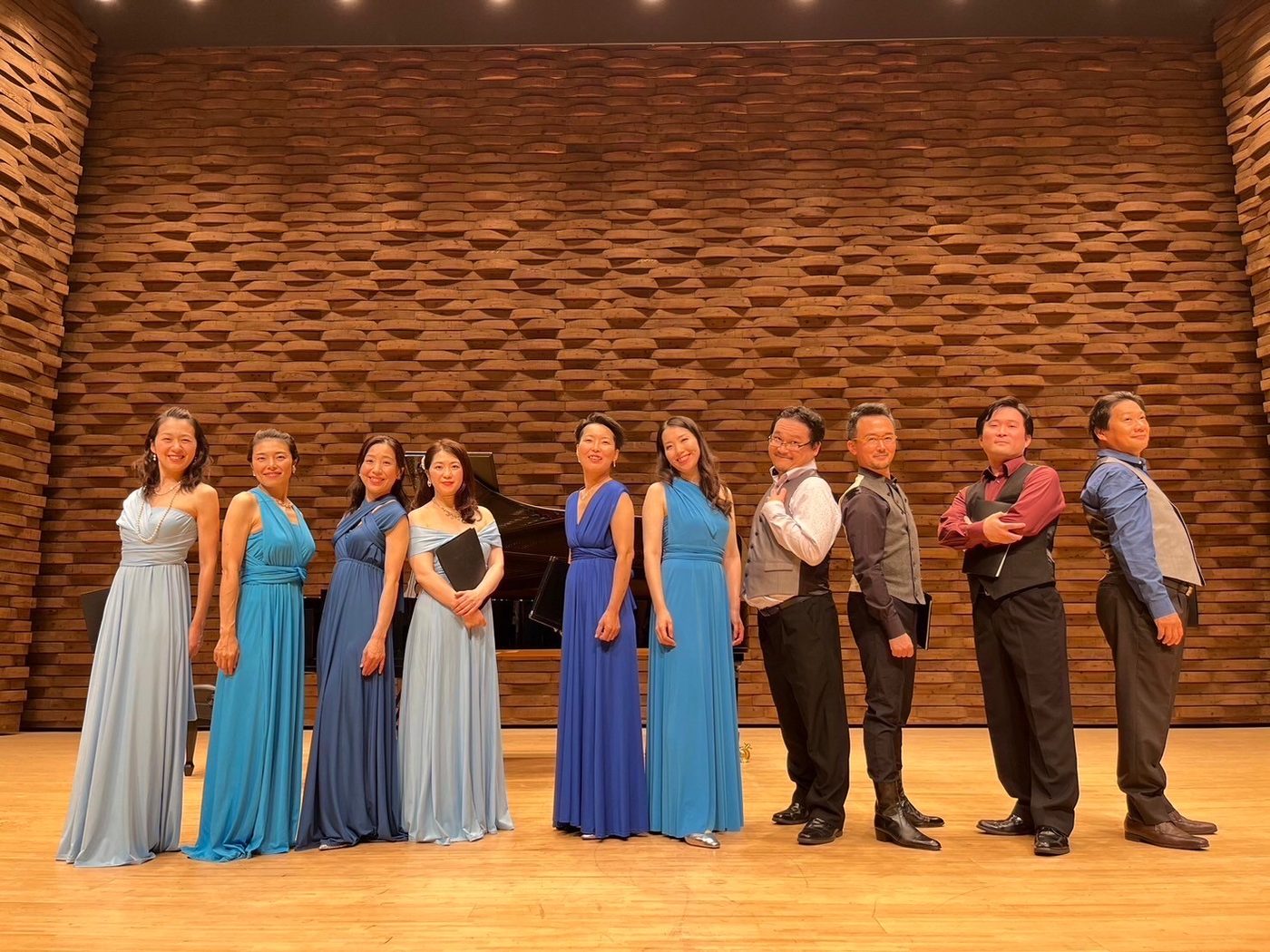 色とりどりの衣装でホールの舞台に並ぶ Radiant Singers