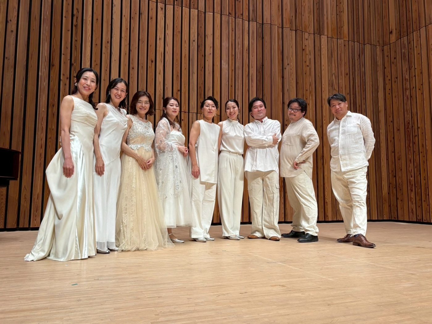 白い衣装でホールの舞台に並ぶ Radiant Singers