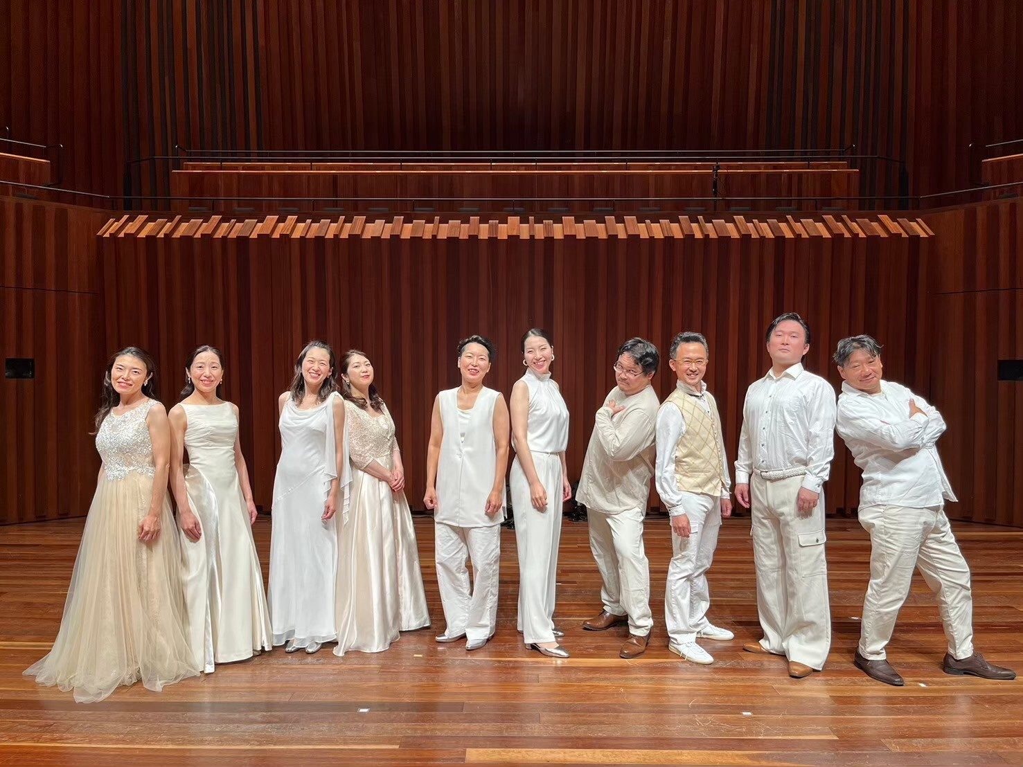 白い衣装で舞台に並ぶ Radiant Singers の10人